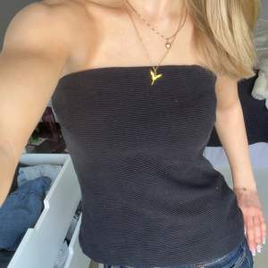 Säljer en stilren svart ribbad tubtopp. Perfekt för en enkel och chic look. Toppen är axelbandslös och har en tight passform som framhäver figuren. Passar utmärkt till både jeans och kjol. Har även band som man får med som gör den till ett linne🥰