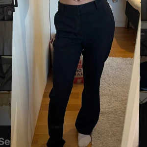 Svarta kostymbyxor från Bik Bok - Snygga svarta kostymbyxor från Bik Bok med dragkedja och knapp framtill. De har en klassisk rak passform och är perfekta för en stilren look. Byxorna har även hällor för bälte.