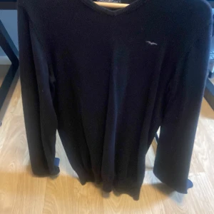 Svart tröja med v-ringning - Säljer en stilren svart tröja med v-ringning och långärmade ärmar. Perfekt för en klassisk look.