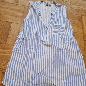 Blå- och vitrandig blus - Blå- och vitrandig blus med fickor från Elitzia. Luftig S i skönt material. Vita knappar. Katt i hemmet.  