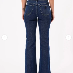 Mörkblå bootcut jeans från abrand  - Snygga blå bootcut jeans med hög midja. Klassisk femficksdesign och knappgylf. Perfekta för en stilren look.