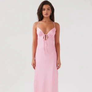 Rosa långklänning med knyt - Elegant rosa långklänning med smala axelband och knytning fram och bak. Perfekt för somriga tillfällen. Köpt från peppermayo för 814kr +dyr frakt. Fråga för egna bilder. 