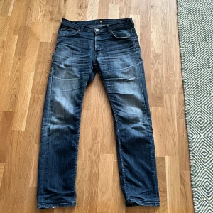 Blå jeans från Lee - Snygga blå jeans från Lee. Storlek 33x32 men schyssta slitningar och lagom blekta