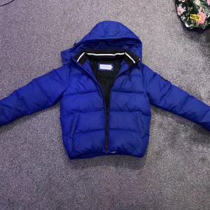 Blå pufferjacka från Calvin Klein Jeans - Säljer en snygg blå pufferjacka från Calvin Klein Jeans. Jackan har en huva och dragkedja framtill. Perfekt för kyliga dagar med sin vadderade design. Den har en stilren logga på bröstet och är helfodrad för extra värme.