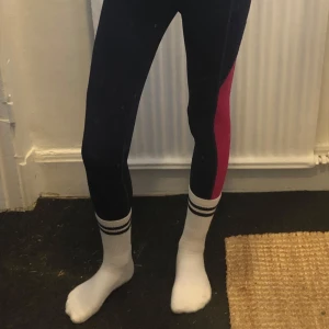 Svarta leggings med rosa detaljer - Snygga svarta leggings med en cool rosa sidopanel. Perfekta för träning eller en avslappnad dag. De har en tight passform som framhäver benen och ger en sportig look.
