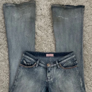 Grå/blå jeans med slitna detaljer - Snygga grå jeans med en cool tvättad look och slitna detaljer. De har en klassisk femficksdesign och en knappgylf. Perfekta för en avslappnad stil. Lite slitna längst ned men absolut inget man tänker på. midjemått 38cm Innebenslängd 86cm.