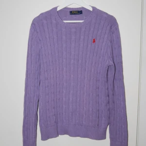 Lila Kabel stickad tröja från Ralph Lauren - Den är i mycket bra skick och gjord i ett väldigt mjukt och bekvämt material. Den enda skavanken är ett mindre märke på ena armen som knappt syns. Den är i storlek L  Den är lite mörkare i färgen i verkligheten   Pris kan diskuteras vid snabb affär