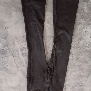 Svarta jeansbyxor från 157 - Snygga svarta jeansbyxor från 157 med en flare-stil. Byxorna har en knapp och dragkedja framtill och är i storlek S med kort längd. Perfekta för en trendig look. Vet inte varför bilden hamnade upp o ner men men