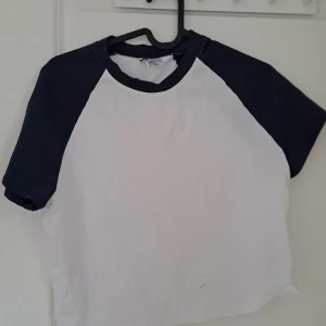 Vit och marinblå t-shirt från H&M Divided - Säljer en vit och marinblå t-shirt från H&M Divided. Den har korta ärmar och en klassisk rund halsringning. Perfekt för en avslappnad stil. 🖤