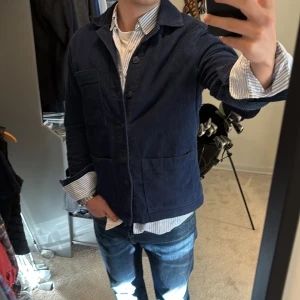 Blå manchesterjacka från These Glory Days - Säljer en snygg blå manchesterjacka/overshirt från These Glory Days. Jackan har en klassisk krage och knäppning framtill med stora fickor. Perfekt för en stilren look. Nypris på denna är runt 1500kr. Skriv om du undrar något!🙌