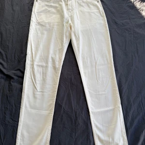 Vita byxor från Morris - Snygga vita byxor från Morris med klassisk design. De har en midwaist och är tillverkade i ett bekvämt material. Perfekta för en stilren look. Nypris 1599 (helt oanvända utan tag)