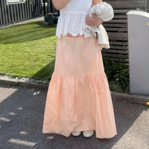 Persikofärgad långkjol - Säljer en vacker persikofärgad långkjol med volangdetaljer. Passar någon mellan 160-170. Går att pruta ner 🩷