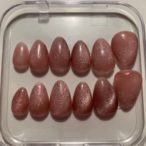 Cat eye gelenaglar - Säljer ett set med glittriga rosa lösnaglar i olika storlekar. Perfekt för att snabbt fixa snygga naglar till festen. Naglarna har en fin glans och en mjuk rosa ton.