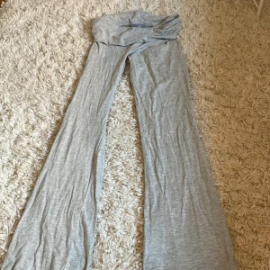 Grå yogapants från Gina Tricot - Supersköna grå byxor från Gina Tricot i mjukt och stretchigt material. De har hög midja och vida ben för en chill och trendig look. Perfekta att styla med en crop top eller hoodie för en avslappnad vibe.