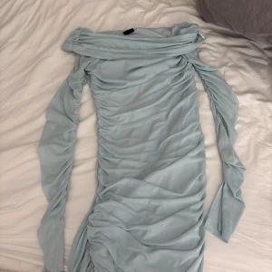 Ljusblå offshoulder kortklänning - Ljusblå tight klänning som är använd en gång. Tyvärr ett märke och litet hål.