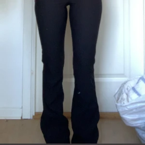 Svarta bootcut kostymbyxor - Säljer ett par svarta kostymbyxor med bootcut-snitt med låg midja. Då byxkanten är tjockare så ser det ut som låg midwaist. Byxorna har två knappar fram, fickor med lock och knapp bak samt är sydda i ett mjukt tyg. Säljer enbart pga att de är för långa för min längd. Om du vill ha flera bilder eller har någon fråga så är det bara att skicka iväg ett meddelande 💕
