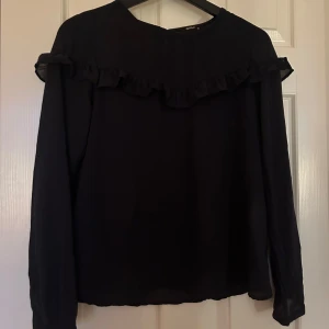 Marin blå blus med volang från Only - Hej, säljer en marin blå blus från Only med långa ärmar och volangdetalj över bröstet och axlarna.💕