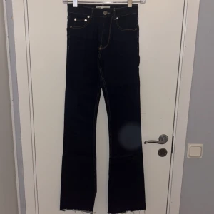 Mörkblå bootcut jeans från Zara - Snygga mörkblå jeans från Zara i bootcut-modell med råa, fransiga benslut. Klassisk femficksdesign, kontrastsömmar och hög midja. Perfekta för dig som gillar en tidlös men trendig look.