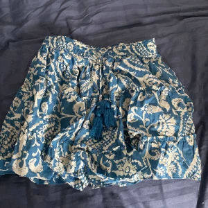 Blåvit kortkjol med snörning -  Säljer en supersöt kortkjol i blått och vitt mönster. Kjolen är från Gina tricot.❤️