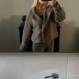 Beige ulljacka från NA-KD, stl 38 - Snygg beige jacka från NA-KD i ullblandning med bred krage och knappar framtill. Jackan har en boxig, lite oversized passform och långa ärmar med knappdetalj vid mudden. Perfekt för höst och vinter när du vill vara både varm och trendig. Pris går att diskutera😇