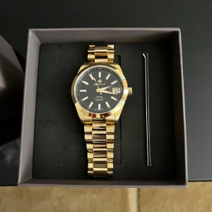 Gant Guld Rostfritt Stål G161005 Herrklocka - Gant Guld Rostfritt Stål G161005 Herrklocka  Elegant och stilren herrklocka från Gant, perfekt för både vardag och fest. Klockan är tillverkad i rostfritt stål med en exklusiv guldfinish som ger ett tidlöst och lyxigt intryck. • Modell: Gant G161005 • Material: Rostfritt stål med guldfärg • Boett: Klassisk rund design • Armband: Länk i rostfritt stål, guldfärgad • Passar till: Alla tillfällen – från kontoret till kvällens middag
