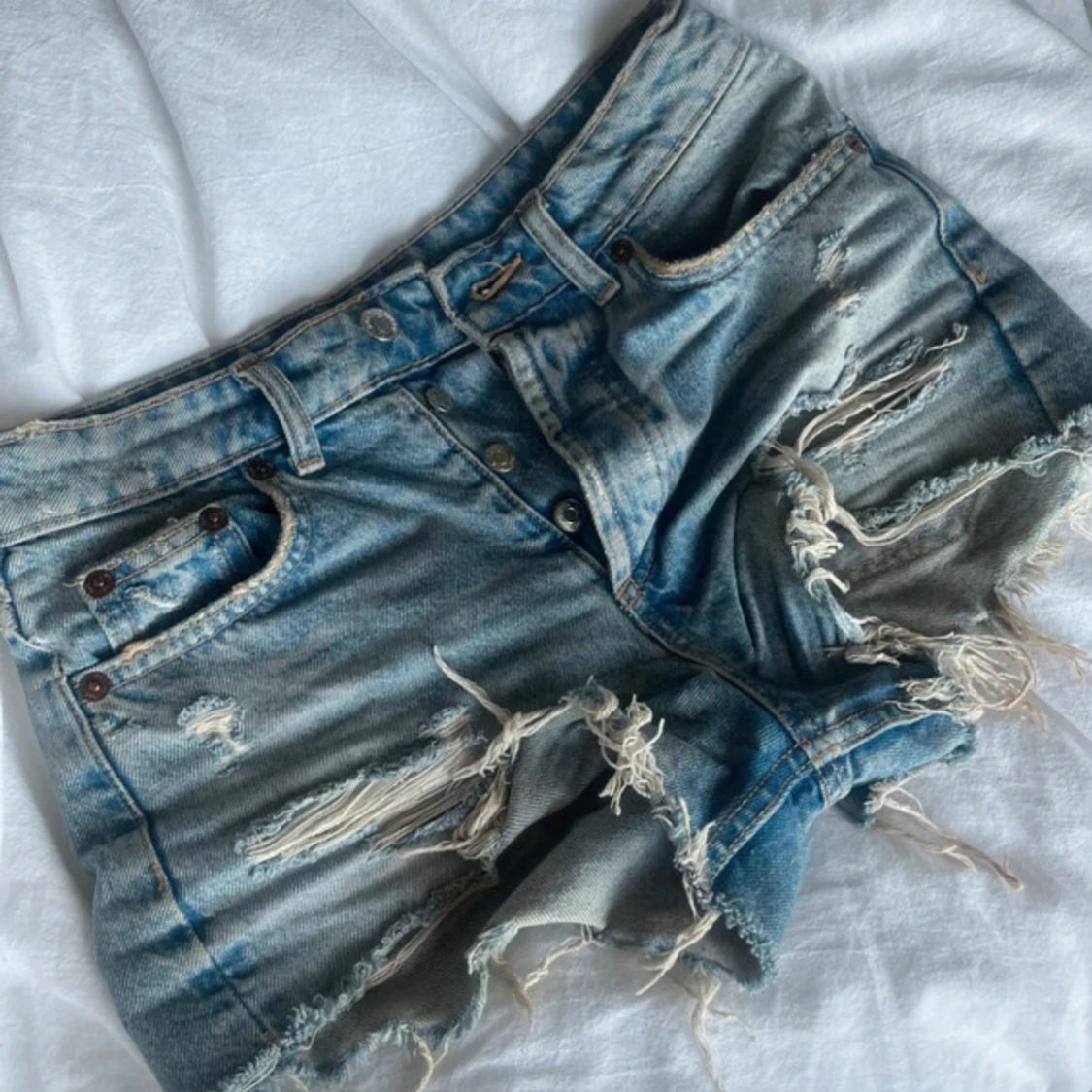 Blå slitna jeansshorts med fransar