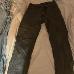 Levi's 501 Premium svarta jeans - Säljer ett par Levi's 501 Premium jeans i svart tvätt. Klassisk rak passform med fem fickor, knappgylf och snygga detaljer som läderpatch och röd Levi's-tag bak. Jeansen är tillverkade i robust denim och har en tidlös look som alltid funkar.