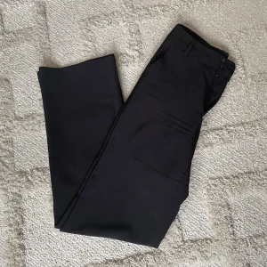 Svarta kostymbyxor från Madlady - Snygga svarta kostymbyxor från Madlady i modellen Tall, perfekta för dig som vill ha lite längre ben. Rak i benen. De passar de som är 170 eller längre och passar även de i strl 36