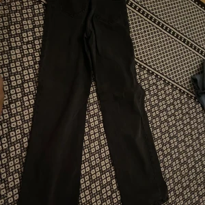 Svarta wide jeans från Lindex - Säljer ett par svarta jeans från Lindex med breda ben och klassisk femficksdesign. Jeansen har en enkel look och är tillverkade i jeansmaterial som känns slitstarkt. Perfekta för dig som gillar en avslappnad och trendig stil.