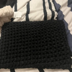 Svart stickad datorväska - Säljer en svart stickad datorväska, hand gjord. Kan köpas som den är eller beställa i annan färg (grå, blå, vit, brun, mixad)