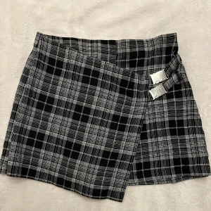 Svartvit rutig short/kjol - Supersnygg svartvit rutig kort short/kjol, det ser ut som en kjol från framsidan och shorts från baksidan. Fråga mig om ni undrar något ^^