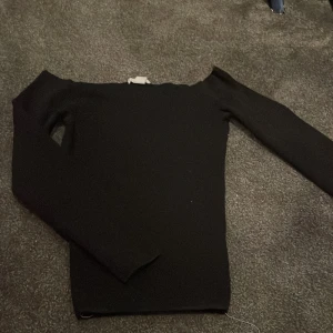 Svart offshoulder topp från H&M - Svart långärmad offshoulder topp från H&M. Snygg och enkel design med tight passform, perfekt att styla med jeans eller kjol. Mjuk och stretchig känsla, passar dig som gillar minimalistiska plagg med en twist. Den är även sydd på insidan men är ingenting man märker av