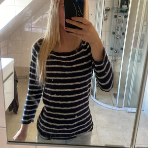 Randig stickad tröja från Havana - Säljer en stickad tröja från Havana i storlek S. Tröjan har marinblå och vita horisontella ränder, rund hals och långa ärmar. Materialet är mjukt och skönt, perfekt för chill dagar. Passformen är normal och den funkar lika bra till jeans som till shorts.