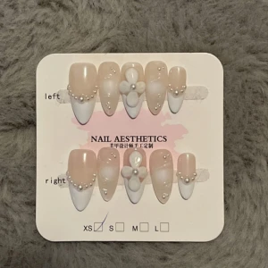 Bridal inspired press on nails - Bridal inspired press on nails 💅 Handgjorda lösnaglar i storlek XS som är lite tjockare och tåliga för att likna akryl naglar. Det gör så att de håller längre eller går att återanvändas! Aldrig använda. Säljer de för de är för små för mig. Tumnagelns bredd är 14mm, pekfinger 11mm, mellanfinger 12mm, ringfinger 10mm, lillfinger 8mm! Kommer med en liten nagelfil och nail glue stickers! Man kan såklart använda nagellim om man har!