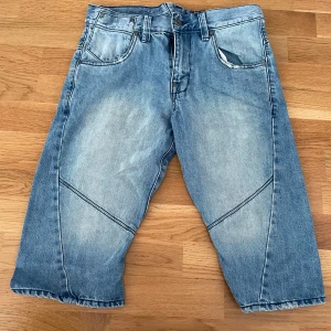 Blå jeansshorts från Emilio Denim - Säljer ett par blå jeansshorts från Emilio Denim med coola sömdetaljer över benen. 