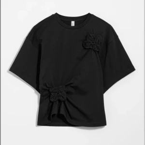 Svart T-shirt med blommor - Svart T-shirt med blomdetaljer från &other stories. Endast använd 1 gång. Nypris 550kr