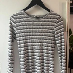 Randig ribbad långärmad klänning - Snygg långärmad klänning från Cubus i storlek 158/164 men är som en Xs. Klänningen är ribbad och har ett randigt mönster i grått och vitt. Den har en rund halsringning och är gjord i mjukt material som sitter skönt mot kroppen. Perfelt för en mysig höst eller vinter dag! Kontakta om du har funderingar!!❤️