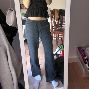 Mörkblå linnebyxor med snörning - Säljer ett par mörkblå linnebyxor med avslappnad passform och resår i midjan. Byxorna har snörning framtill och raka ben, samt praktiska fickor på sidorna. Perfekta för dig som gillar en chill och luftig stil.