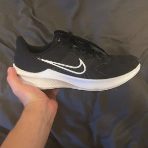 Svarta Nike sneakers med vit sula - Säljer ett par svarta Nike bekväma skor. Endast använda inomhus fåtalet gånger storlek 42 