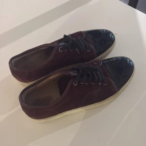 Lanvin Sneakers vinröda - Vinröda Lanvin sneakers i storlek 10 eller EU 43, små defekter, men med lite rengöring av sulan och byte av skosnöre är dom som nya