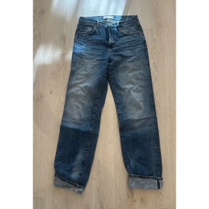 Jeans straight / boyfriend fit - Klassiska Zara jeans i mörkblå tvätt med snyggt slitna detaljer. Rak passform  med uppvikta benslut. 