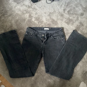Svarta bootcut jeans från Gina  - Snygga svarta jeans från Gina Perfect Jeans i modell bootcut. Jeansen har klassisk femficksdesign, dragkedja och knapp framtill samt bälteshällor. Materialet är jeans i bomull och passformen är normal med utsvängda ben. (Saknar en knapp)