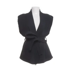 Svart omlottväst från H&M med knyt - Stilren marinblå väst från H&M i omlottmodell med breda axlar och knytband i midjan. Västen har en djup v-ringning och markerad midja för en snygg siluett. Perfekt att slänga över en skjorta eller t-shirt för en cool layering-effekt.