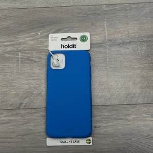 Blått silikonfodral Holdit iPhone 11/XR - Snyggt blått silikonfodral från Holdit som passar iPhone 11 och XR. Fodralet har en clean look och skyddar mobilen med en mjuk och greppvänlig yta. Perfekt för dig som vill ha en stilren vibe och samtidigt hålla mobilen safe.