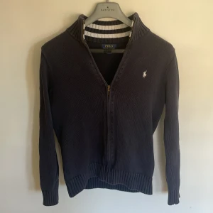 Mörkblå stickad tröja Polo Ralph Lauren - Mörkblå stickad tröja från Polo Ralph Lauren. Tröjan sitter som S. Inga hål osv. Den är köpt secondhand. Har ni funderingar är det bara att skicka🎱