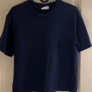 Mörkblå basic t-shirt - En enkel och stilren mörkblå t-shirt med rund hals och korta ärmar. Perfekt för dig som gillar en clean och klassisk look. 