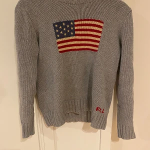 Ralph lauren tröja - Säljer denna snygga gråa ralph lauren tröjan med USA flaggan på. Jag säljer den eftersom att den har blivit för liten. Det är bra skick 7-10