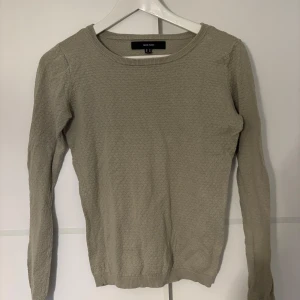 Olivgrön tröja från Vero Moda - Säljer en olivgrön tröja från Vero Moda med diskret strukturmönster. Tröjan har rund halsringning och långa ärmar, perfekt för att hålla dig varm under kyliga dagar. Enkel och stilren design som funkar till många olika outfits.