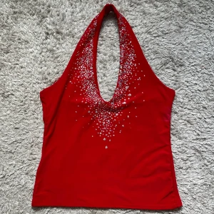 Röd halterneck topp med strass från Vila - Snygg röd halterneck topp från Vila i storlek M. 