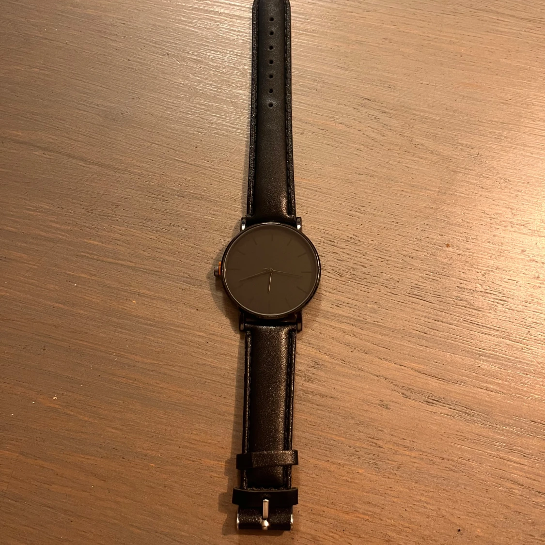 Svart minimalistisk klocka med läderband